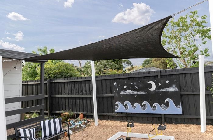 A charcoal shade sail is put up 