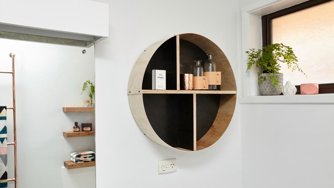 A round shelf unit containing decorative bottles and perfume
