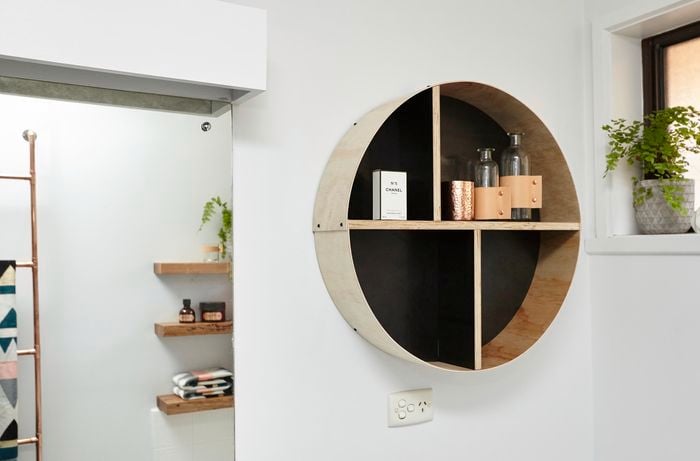 A round shelf unit containing decorative bottles and perfume