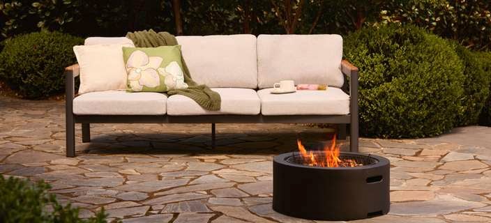 Outdoor lounge and a fire pit outside on a paved area.