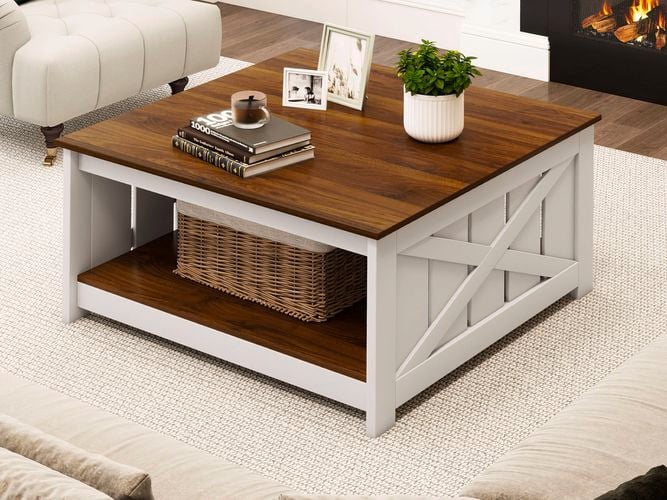 A coffee table sitting on a rug in front of a beige couch in a lounge room.