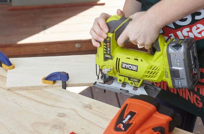 A jigsaw being used to cut a panel of wood for a bird nesting box roof