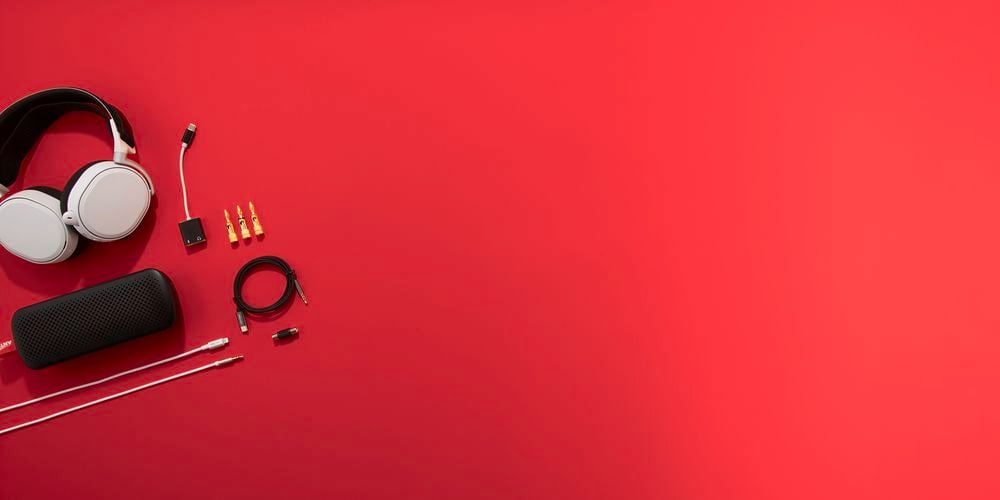 Bright red background with audio products laid out on left side