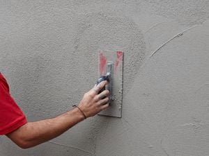 Bunnings team member applying a top coat to render