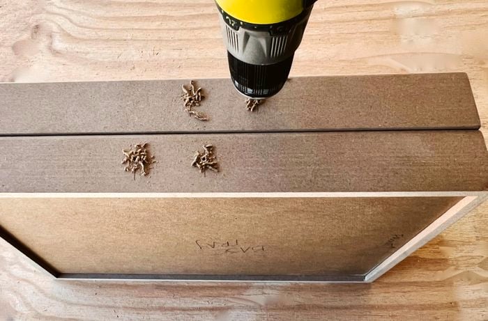 A drill used to pre-drill holes in the sides of MDF trays.