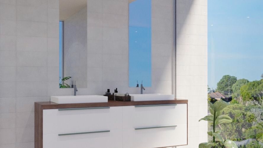 Bathroom with two mirrors along with two wash basins with two taps and drawers underneath, plant and white wall tiles.