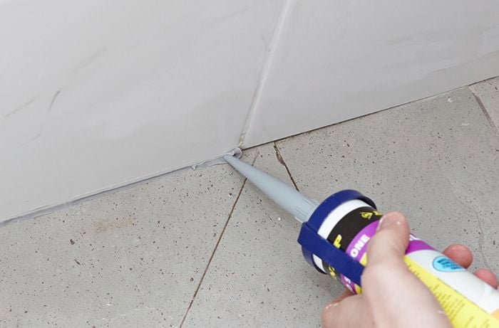 Sealant being used to fill gaps in a bathroom