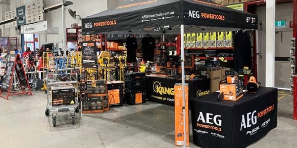 AEG Powertools pop‑up stand inside a Bunnings warehouse featuring power tool displays, signage and demo tables.