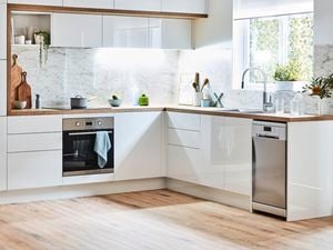 kitchen with glossy white cabinets and stone splashback