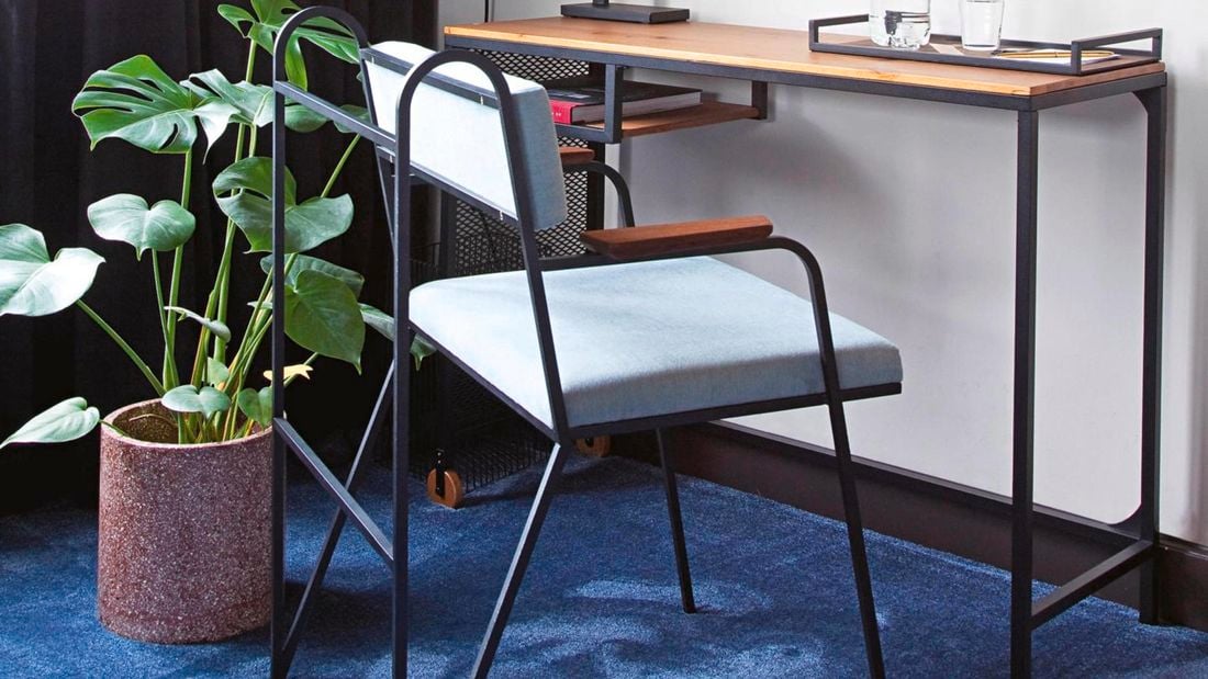 Chair, desk and potted plant in a living room with curtains