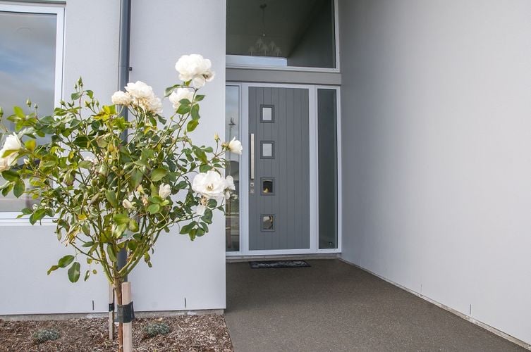 Front entryway to home with grey door and white roses
