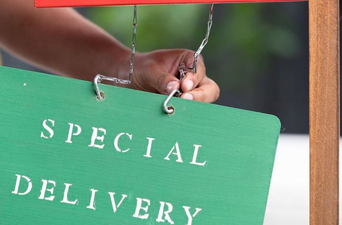 A Bunnings Team Member hanging up a Special Delivery sign to a letterbox