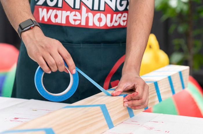Placing blue masking tape on timber