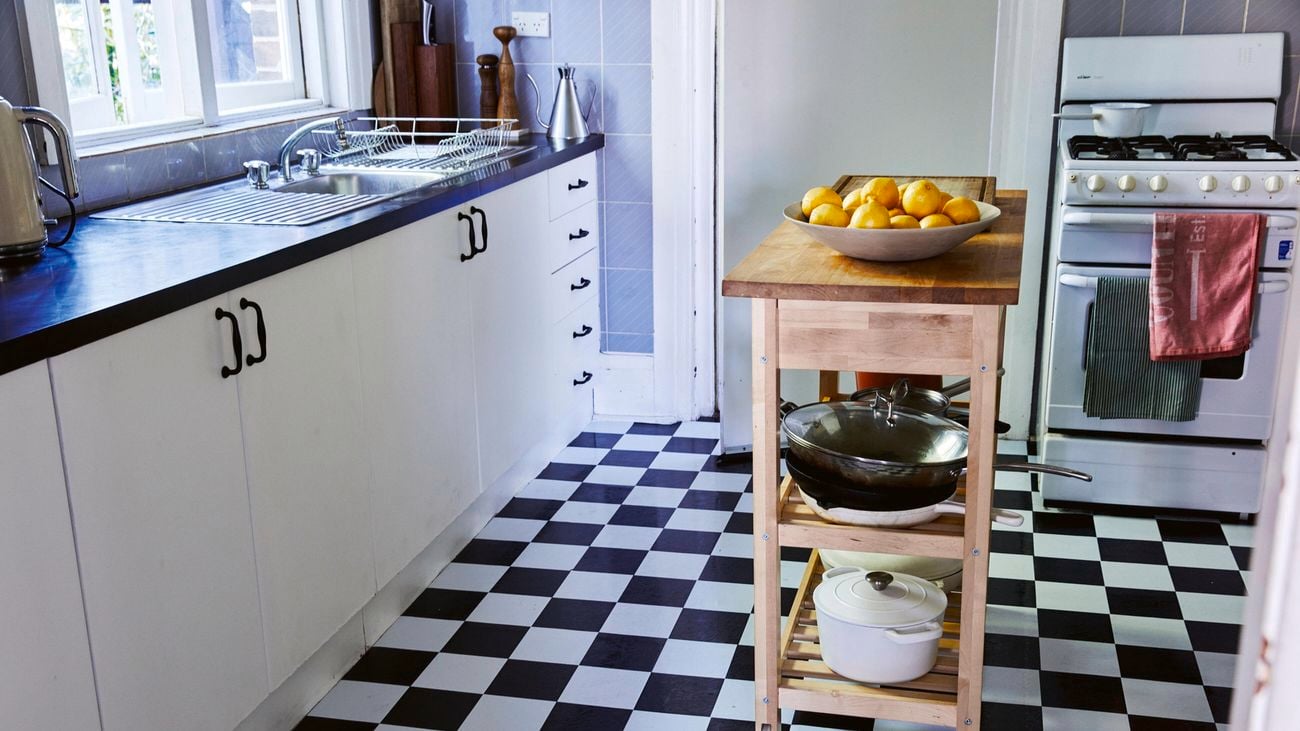 Kitchen with checkerboard tiles and portable benchtop.