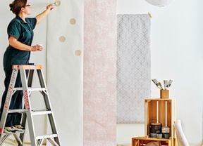 Woman painting circles on a paper strip on a wall.