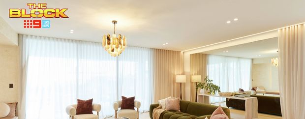Contemporary living room featuring curved olive-green sofas, neutral armchairs, a chandelier and soft floor-to-ceiling curtains.