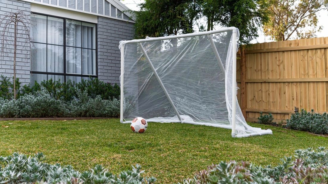 diy soccer goal in front yard of house with soccer ball on lawn