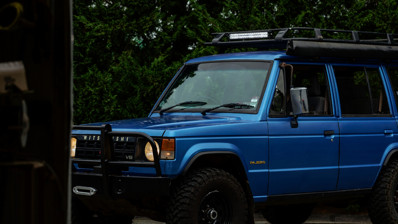 KT 20'' Double Row LED light bar mounted to roof rack on blue 4WD vehicle.
