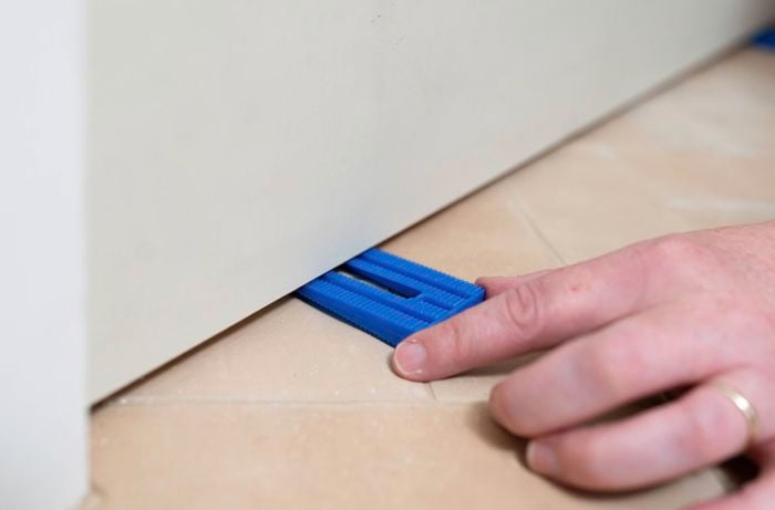 A door is supported with wedges to align the door correctly in the frame before fixing the hinges permanently. 