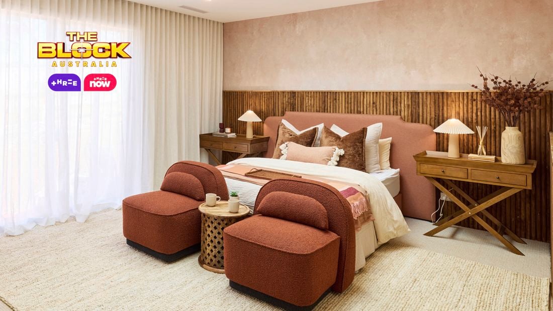  Bedroom with peach tones, wooden accents, and two upholstered chairs.