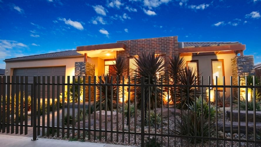 Front of house with blade fence and native plants.