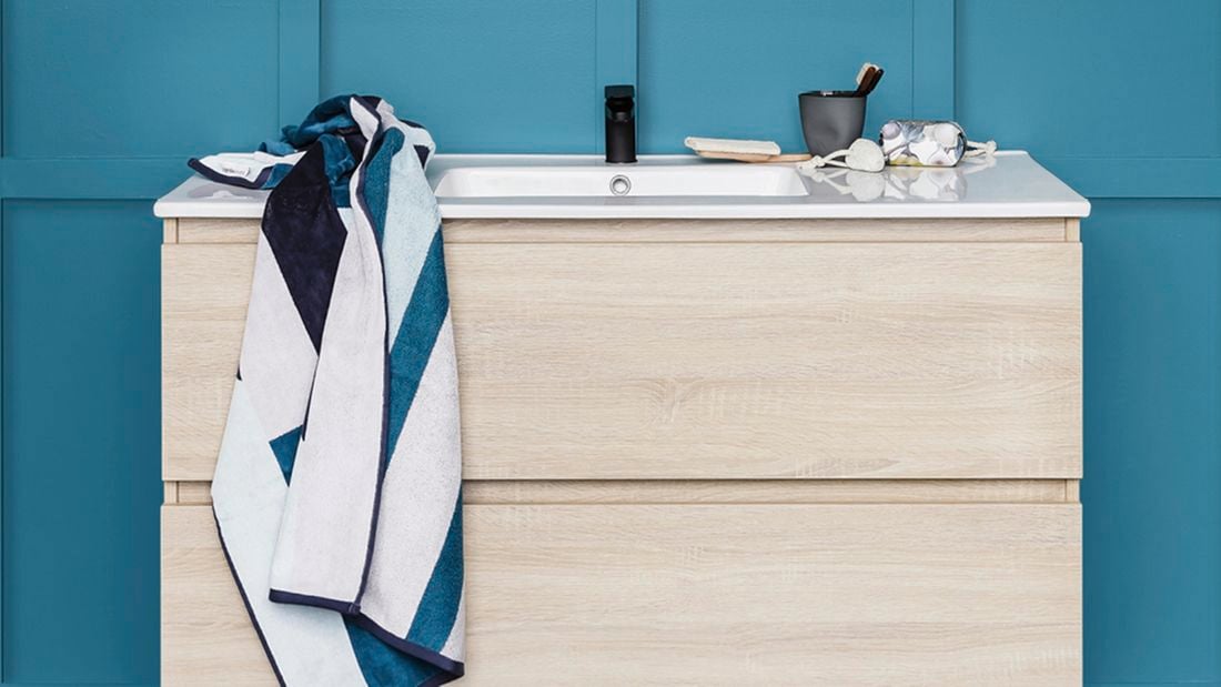 Bathroom vanity with blue and white striped towel. 