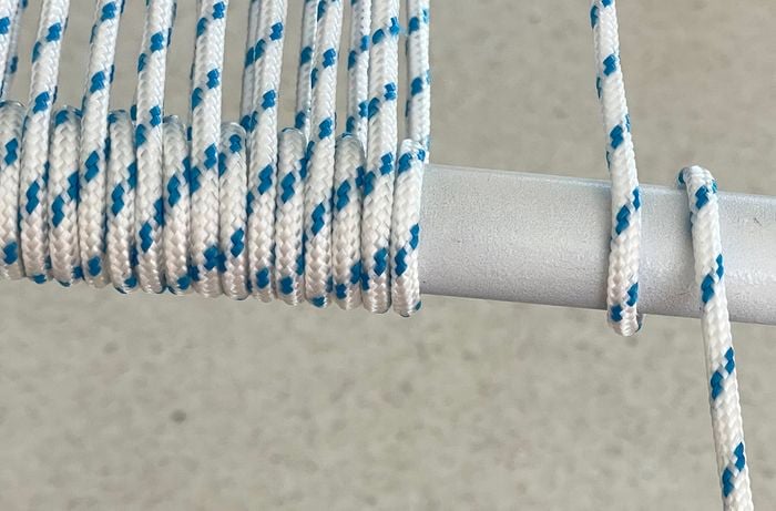 Bring new life to a damaged patio chair with D.I.Y. outdoor chair weaving – start by carefully winding weatherproof rope around the frame for a sturdy and stylish finish. 