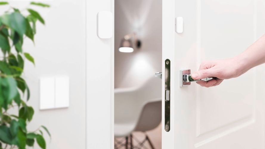 Aqara door and window sensor mounted on a white door