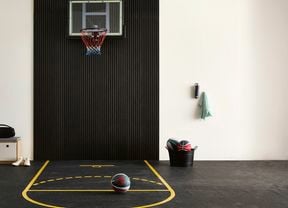 A mini basketball court for your garage with a hoop and court lines on rubber flooring.