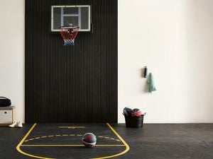 A mini basketball court for your garage with a hoop and court lines on rubber flooring.