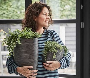Woman holding two pot plants