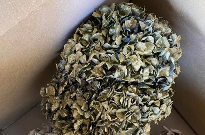 3 bunches of dried flowers in a cardboard box