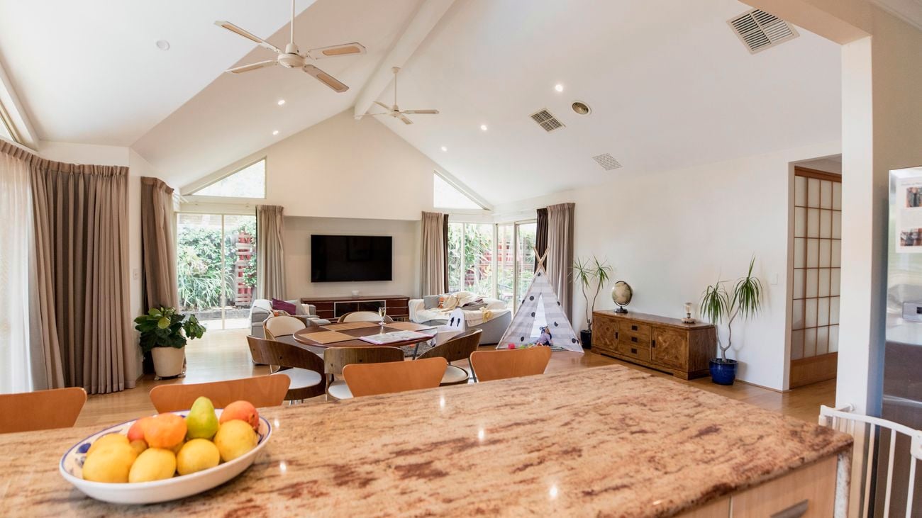 Open-plan kitchen and living space featuring two ceiling fans