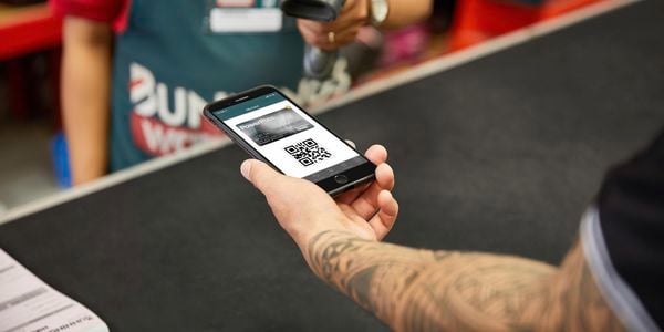 Bunnings team member preparing to scan PowerPass app on customers phone.