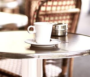 Close up of a metal table top with a coffee cup