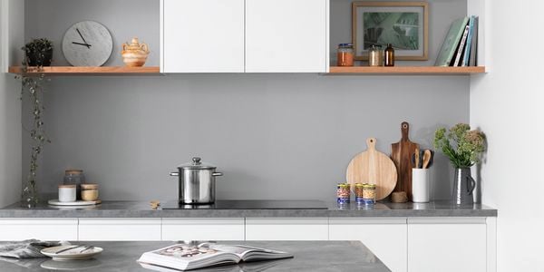 Renovated kitchen featuring white cabinetry and grey benchtops.