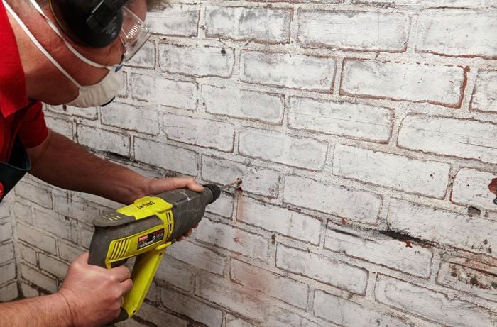 Person drilling into a wall.