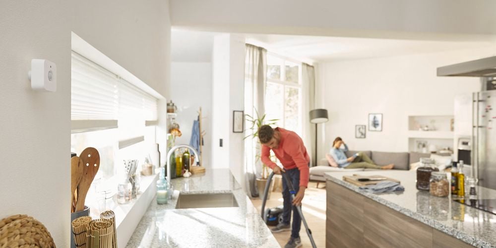 Philip hue brand - man vacuuming kitchen floors