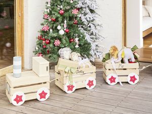 Personalised wooden gift train displayed beside a decorated Christmas tree.