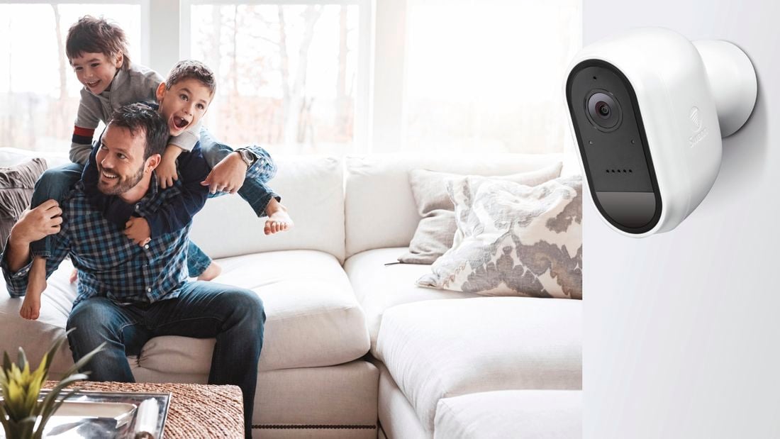 Father playing with his two children, Home security camera is in the foreground