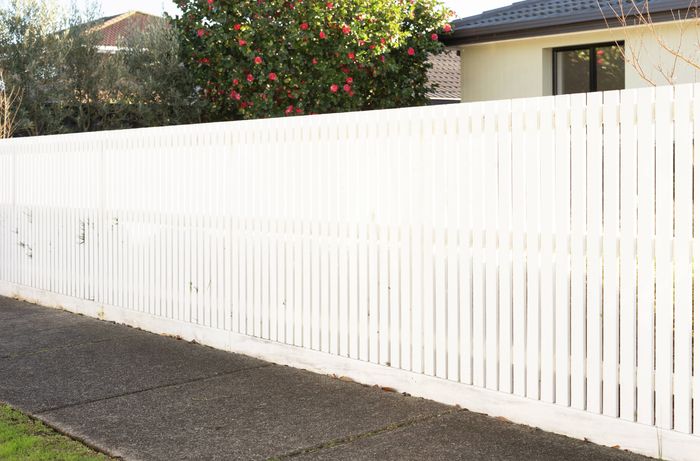 Modern picket fence on a clear day before spray painting​​​​​ 