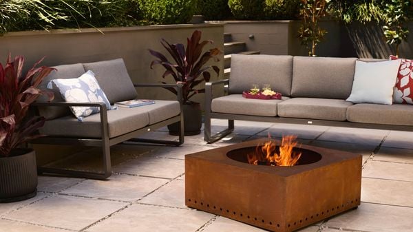 A fire pit and an outdoor setting on a paved area outside.