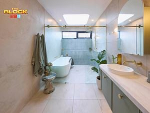 Green, gold and white coloured bathroom with a timber fluted profile vanity and marble benchtop and bath