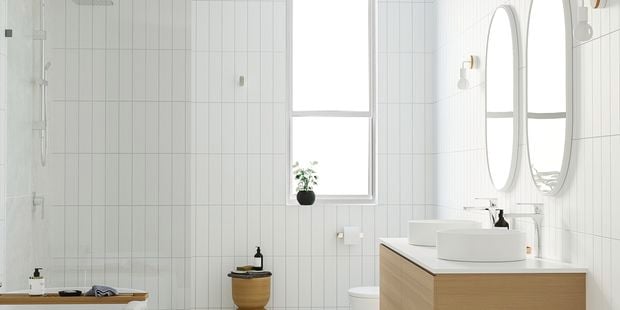 modern bathroom with white tiles, freestanding bath, timber vanity and double mirrors
