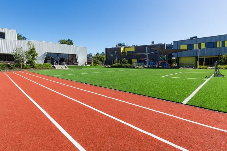 An athletics track overlooking a marked soccer pitch with goals