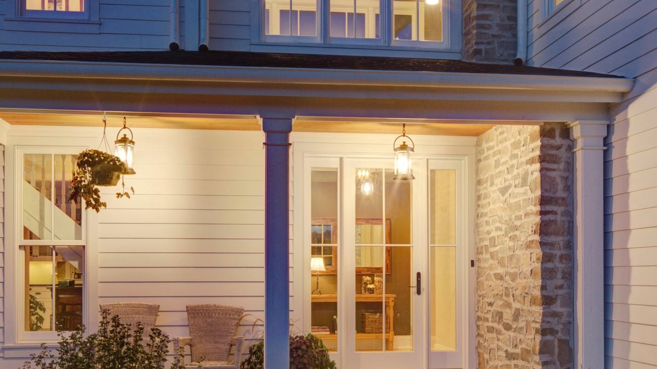 Outdoor of a two-story house, lit up by outdoor hanging lights near the door.
