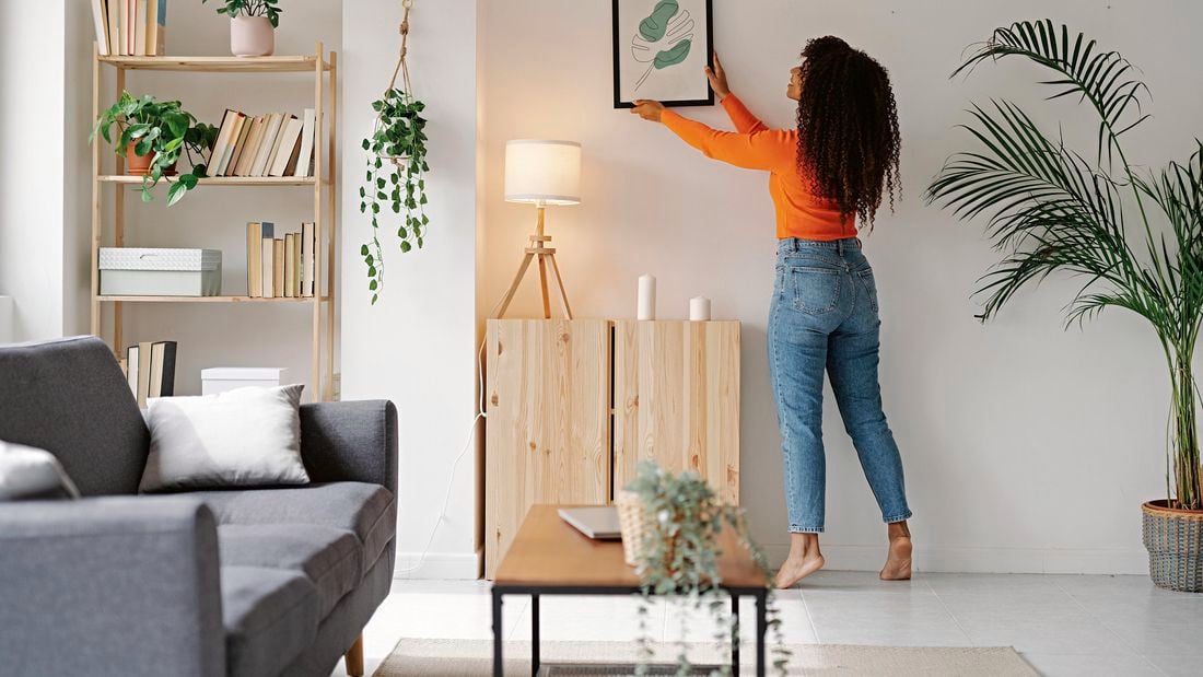 photo frame being hung in living room with freshly painted wall