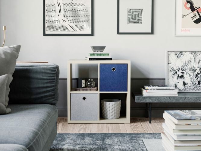 A lounge room with a couch, cube shelving unit and a coffee table in it