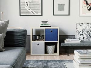 A lounge room with a couch, cube shelving unit and a coffee table in it