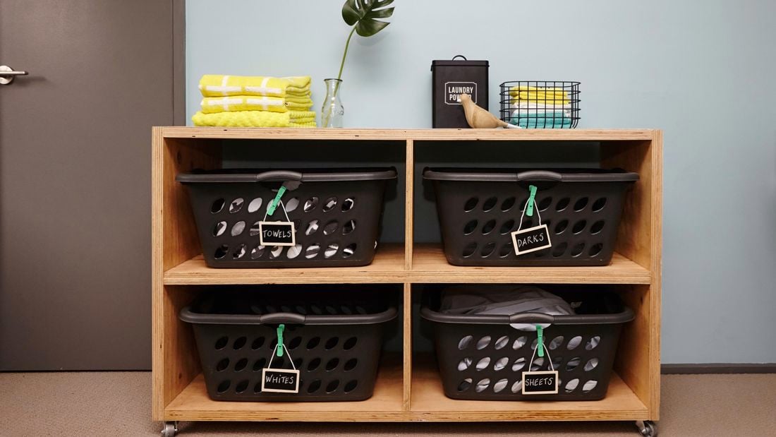 A completed laundry basket dresser with four marked laundry baskets